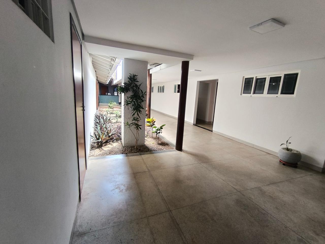 Corredor interno da clínica com jardim e luz natural
